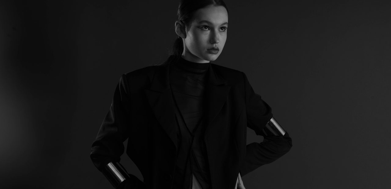 Editorial fashion campaign — tailored black look on a dramatic studio backdrop